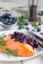 Baked salmon fillet with blueberry rosmarin sauce on white plate Royalty Free Stock Photo