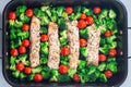 Baked salmon fillet with broccoli and tomato on frying tray, horizontal, top view