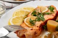 Baked salmon fillet medallion with salad of pickled vegetables and mushrooms on a white plate on a gray background, close up