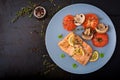 Baked salmon fish fillet with tomatoes, mushrooms and spices. Royalty Free Stock Photo