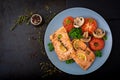 Baked salmon fish fillet with tomatoes, mushrooms and spices. Royalty Free Stock Photo