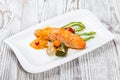 Baked salmon garnished with physalis, asparagus, tomatoes with herbs Royalty Free Stock Photo