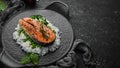 Baked salmon steak with rice and vegetables on a black stone plate. Seafood. Top view. Royalty Free Stock Photo