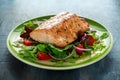 Baked salmon steak with tomato, onion, mix of green leaves salad in a plate. healthy food Royalty Free Stock Photo