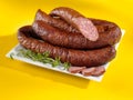 Baked sausages on a plate and yellow background