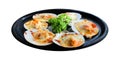 Baked Scallops with Cheese and green Parsley black ceramic dish isolated on white background with clipping path. Grill seashell Royalty Free Stock Photo