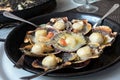 Baked scallops with cheese and spicy sauce. Delicate clam is a real pleasure. Romantic dinner at a Spanish fish restaurant.