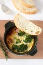Baked scrambled eggs with broccoli, sausages and cheese served with slices of bread. Rustic style. Royalty Free Stock Photo