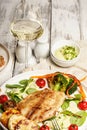 Baked sea fish with vegetables and a glass of white wine. Tilapia fillet with broccoli, cherry tomatoes and lettuce. Sea food on a Royalty Free Stock Photo