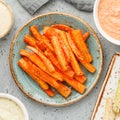 Baked season carrot sticks with sauce and hummus. Vegetarian healthy food