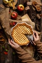 Baked sliced apple lattice pie crust in woman hands on sackcloth Royalty Free Stock Photo