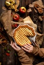 Baked sliced apple lattice pie crust in woman hands on sackcloth Royalty Free Stock Photo