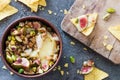 Baked soft cheese brie with figs, walnuts, pistachios and honey in a bowl
