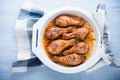 Baked spicy chicken legs with sesame on blue wooden background