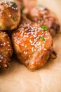 Baked spicy chicken legs with sesame and parsley on paper background