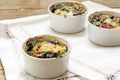 Baked spinach with cheese in small casserole servings, white nap