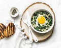 Baked spinach eggs - delicious breakfast, brunch, snack on a light background