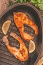 Baked steak trout fish in cast-iron form, around greens, leaves,