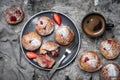 Baked strawberry muffins with powder sugar on a plate served with coffee