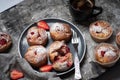 Baked strawberry muffins with powder sugar on a plate served with coffee