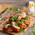 Baked stuffed chicken rolls on a wooden board. Fork, knife, salt shaker, parsley on a wooden table. Rustic style Royalty Free Stock Photo