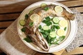 Baked stuffed fish luce with lemon and cucumber slices, parsley on white plate on wooden background Royalty Free Stock Photo