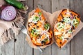 Baked, stuffed sweet potatoes, above view on rustic wood