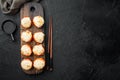 Baked sushi maki rolls with salmon, crab, cucumber, avocado, flying fish roe and spicy sauce, on black stone background, top view Royalty Free Stock Photo