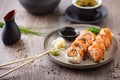 Baked sushi maki rolls with salmon, crab and spicy sauce on a plate with chopsticks, soy sauce, wasabi and ginger Royalty Free Stock Photo