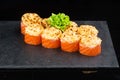baked sushi with salmon avocado red caviar and cream cheese isolated on black background. Delicious traditional Japanese food Royalty Free Stock Photo