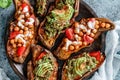 Baked sweet potato toast with roasted chickpeas, tomatoes, goat cheese, sauce guacamole, avocado, seedlings on wooden board over