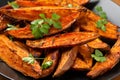 Baked Sweet potato wedges, fries served on black plate Royalty Free Stock Photo