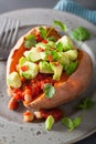 Baked sweet potatoes with avocado chili salsa and beans