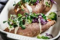 Baked sweet potatoes stuffed with quinoa, broccoli and cabbage, dark background