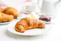 Baked tasty croissant on plate on white table Royalty Free Stock Photo