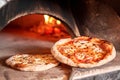 Baked tasty margherita pizza in Traditional wood oven in Naples restaurant, Italy. Original neapolitan pizza. Red hot Royalty Free Stock Photo