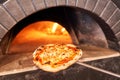 Baked tasty margherita pizza in Traditional wood oven in Naples restaurant, Italy. Original neapolitan pizza. Red hot Royalty Free Stock Photo