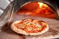 Baked tasty margherita pizza in Traditional wood oven in Naples restaurant, Italy. Original neapolitan pizza. Red hot Royalty Free Stock Photo
