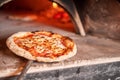 Baked tasty margherita pizza in Traditional wood oven in Naples restaurant, Italy. Original neapolitan pizza. Red hot Royalty Free Stock Photo