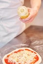 Pours olive oil. Baked tasty margherita pizza in Traditional wood oven in Naples restaurant, Italy. Original neapolitan Royalty Free Stock Photo