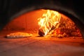 Baked tasty margherita pizza in Traditional wood oven in Naples restaurant, Italy. Original neapolitan pizza. Red hot Royalty Free Stock Photo