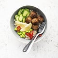 Baked teriyaki meatballs with brown rice, cucumbers, hot pepper, lemon slices in a bowl. Top View Royalty Free Stock Photo