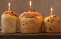 Baked traditional religious easter holiday sweet cake also called kulich with raisins and burning candle on vintage textile Royalty Free Stock Photo