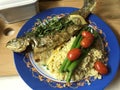 Baked trout on a cushion of bulgur with vegetables, asparagus and tarragon. Royalty Free Stock Photo