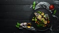 Baked trout fish with vegetables and lemon on a black plate. Top view. Royalty Free Stock Photo