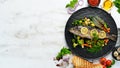 Baked trout fish with vegetables and lemon on a black plate. Top view. Royalty Free Stock Photo