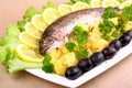 Baked trout and potatoes, olives, lemon with salad