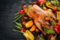 Baked turkey with vegetables and spices. Thanksgiving day. Goose chicken grill. On a wooden background. Royalty Free Stock Photo