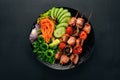 Baked veal shish kebab on a plate with fresh vegetables. On a wooden background. Top view.