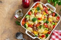 Baked vegetable and sausages lumaconi pasta in white baking dish